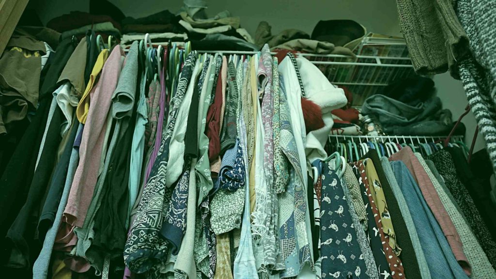 Clothing closet that needs to be decluttered and organized.